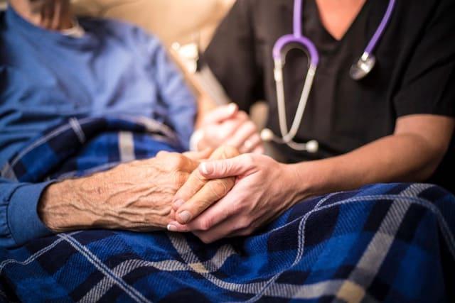 nurse and patient holding hands